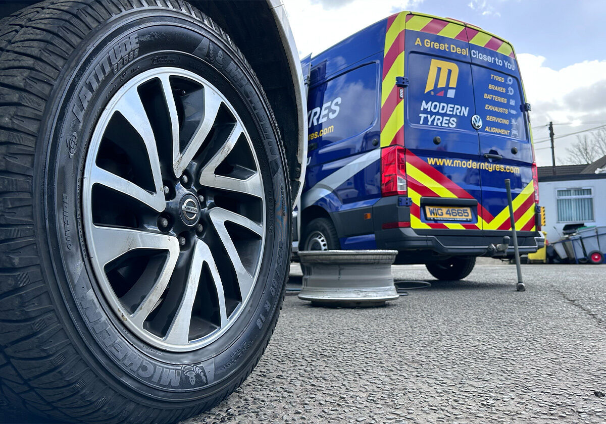 Modern Tyres technician changing a tyre at the roadside